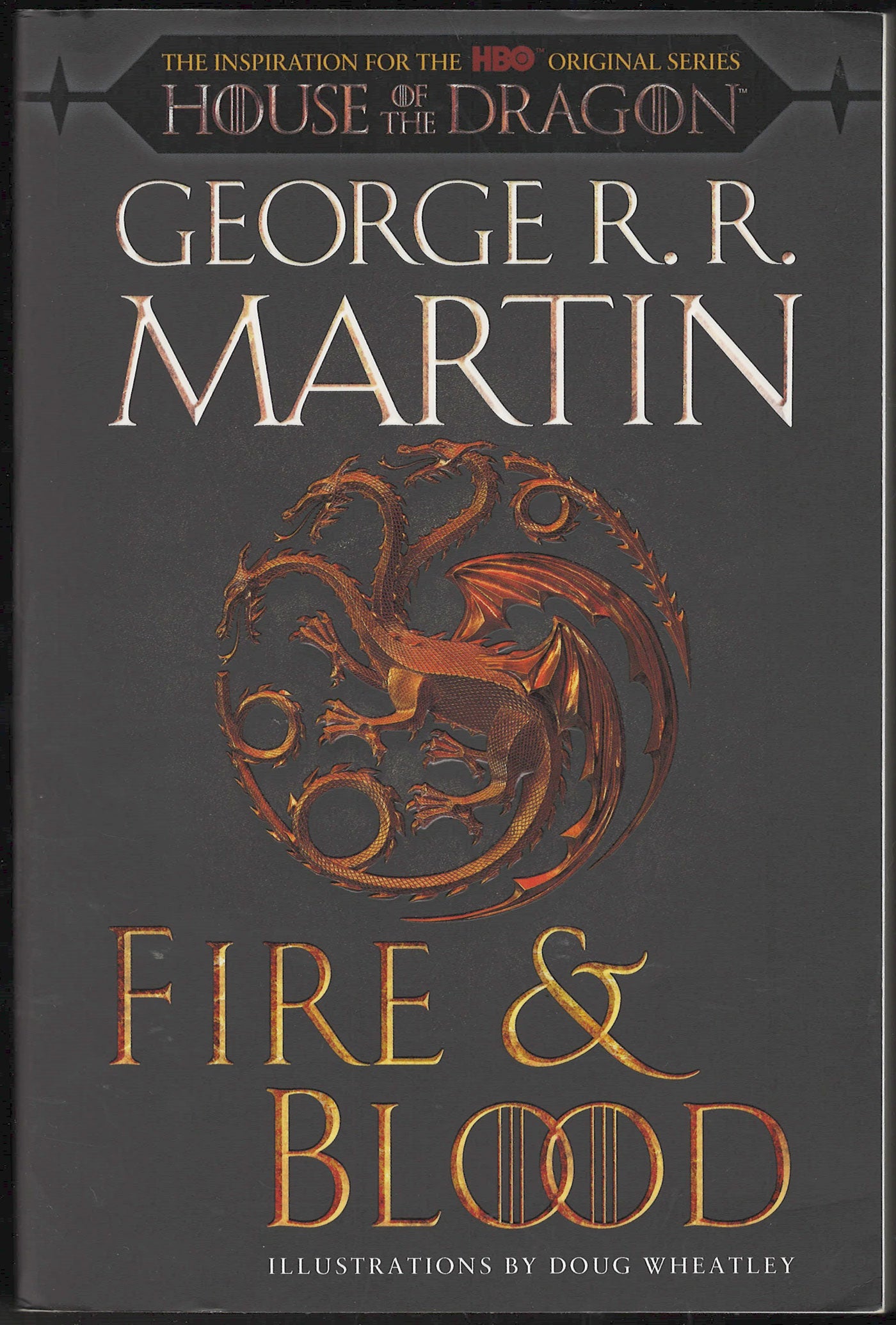 Front cover of Fire & Blood by George R.R. Martin with a dragon emblem on a dark background.