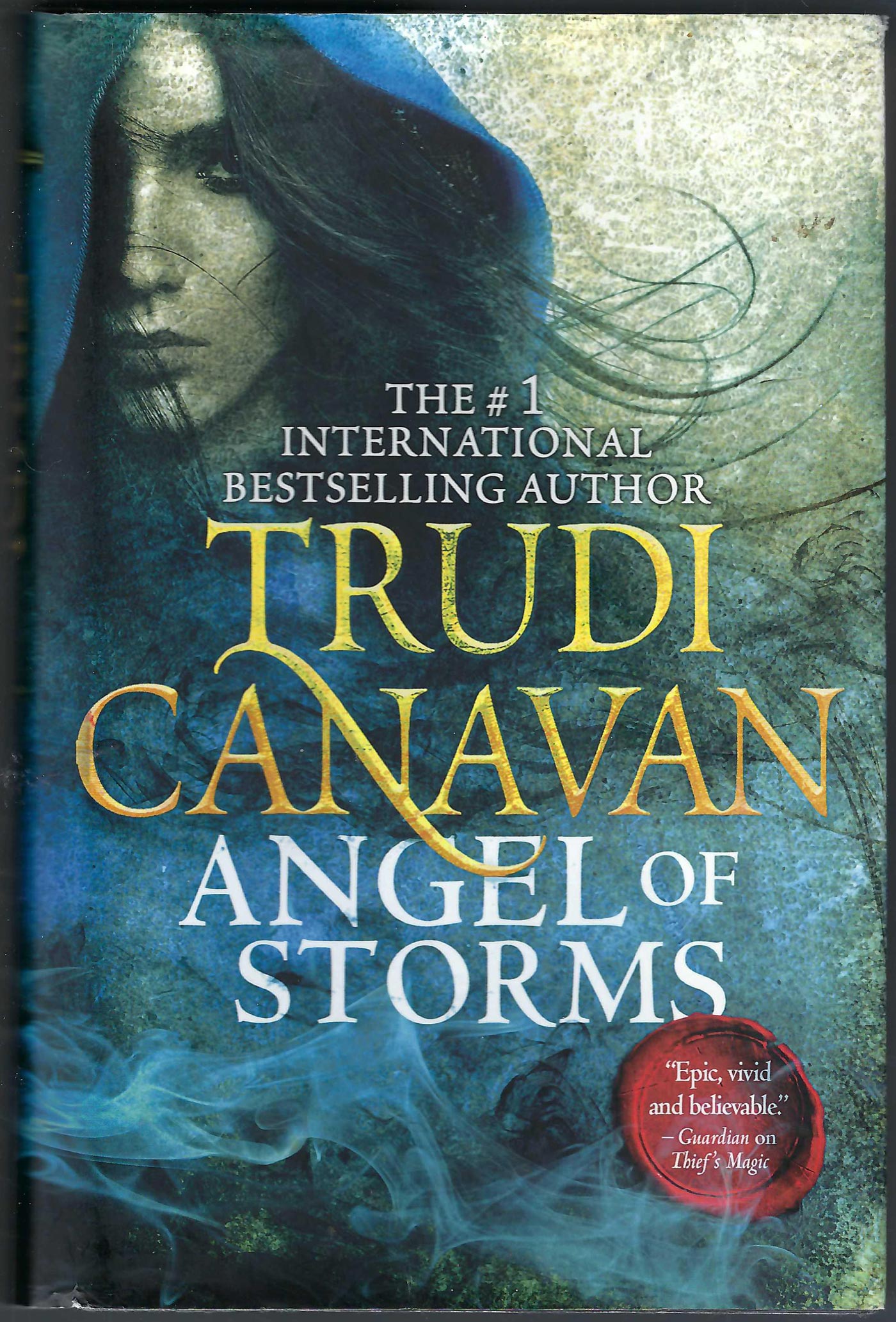 Front cover of Angel of Storms by Trudi Canavan with an image of a woman in a blue cloak