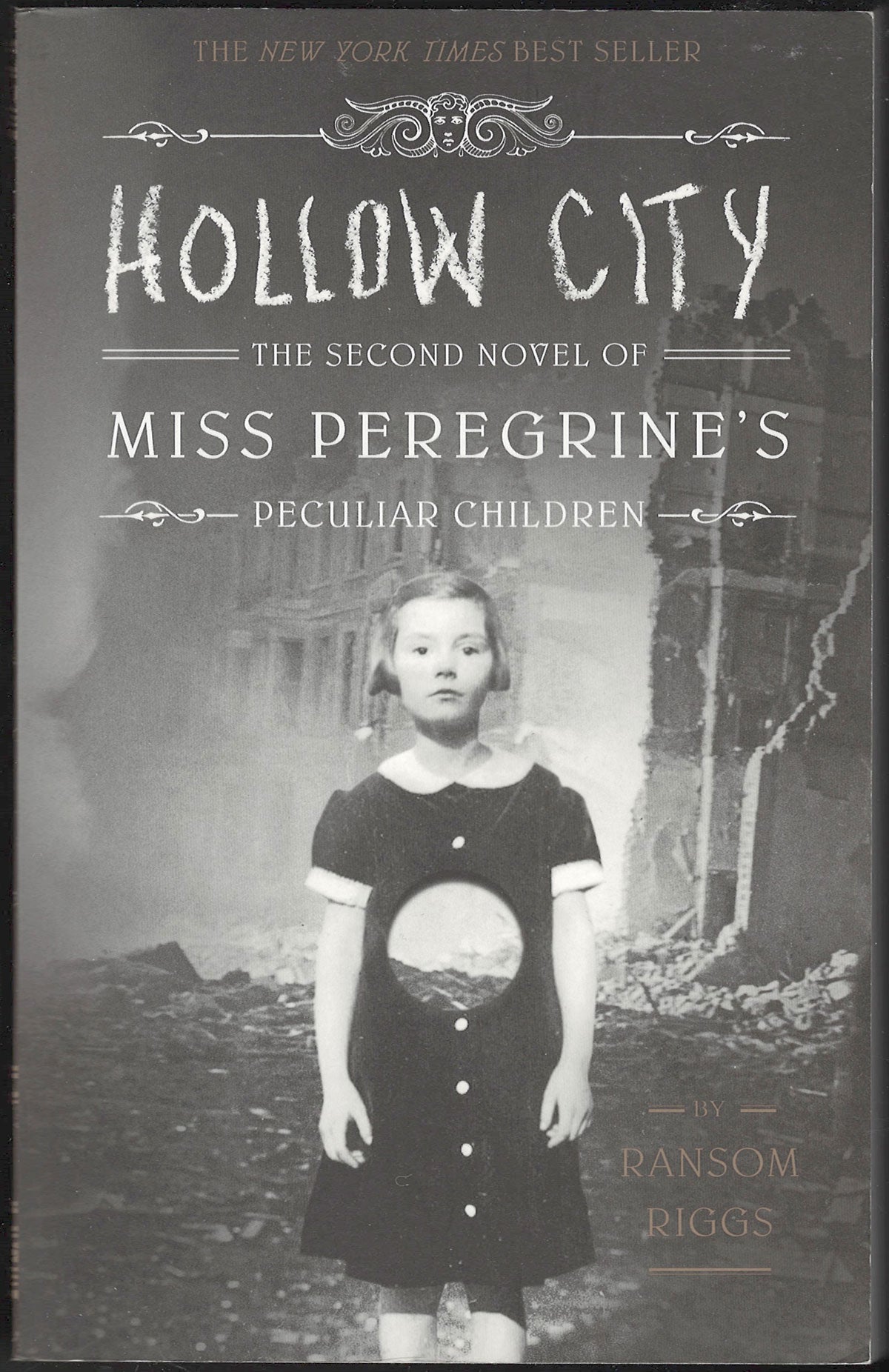 Front cover of Hollow City by Ransom Riggs featuring a peculiar image of a young girl in a black dress.