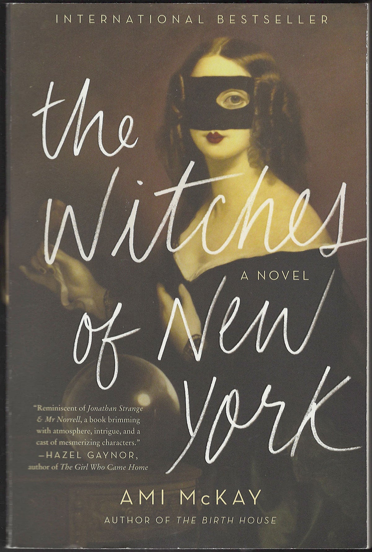 Front cover of The Witches of New York by Ami McKay with a woman wearing a mask.