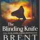 Front cover of The Blinding Knife by Brent Weeks with a silhouette of a cloaked figure walking up stairs into a fiery sky.