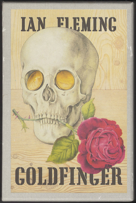 Cover of slipcase of Goldfinger by Ian Fleming featuring a skull and rose on a wooden texture background.
