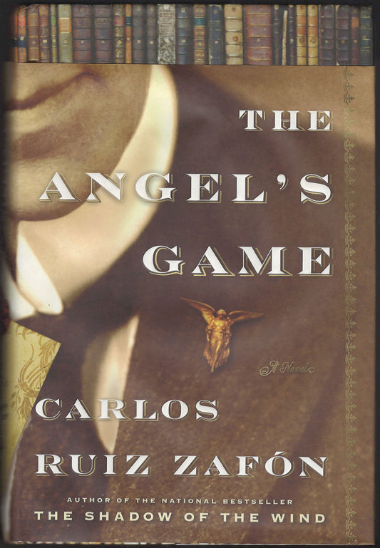 Front cover of The Angel's Game by Carlos Ruiz Zafón with a close-up and an angelic pin.
