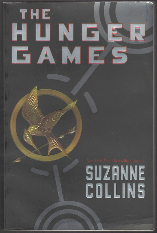 Front cover of The Hunger Games by Suzanne Collins with a dark background and a gold emblem.