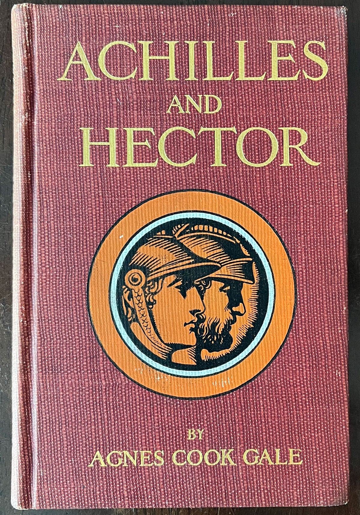 Front cover of Achilles and Hector by Agnes Cook Gale with a maroon background and circular emblem.