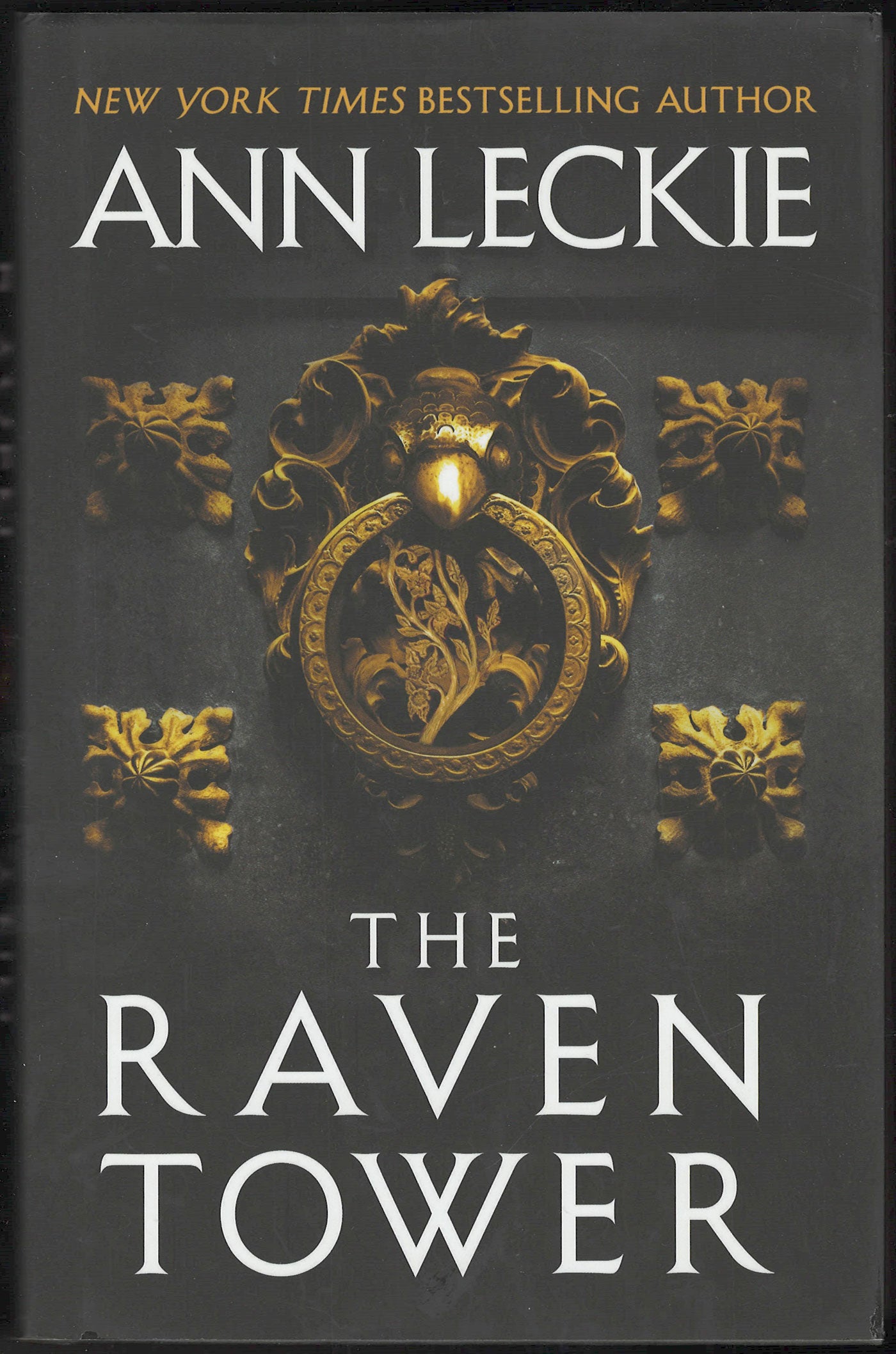 Front cover of The Raven Tower by Ann Leckie with a dark background and gold emblem.