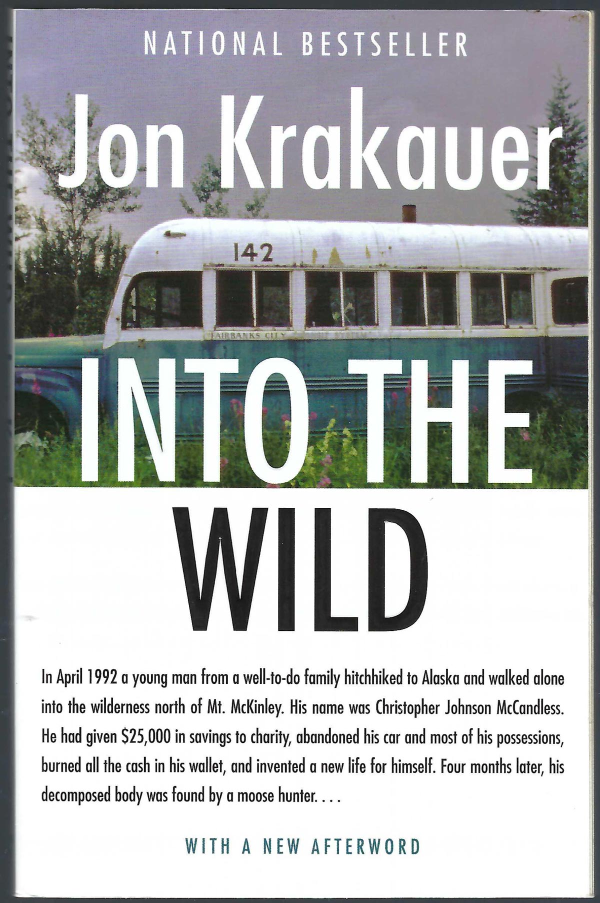 Front cover of Into the Wild by Jon Krakauer, featuring a vintage green and white bus on a grassy background with large white and black title text.