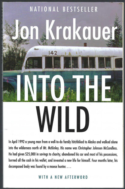 Front cover of Into the Wild by Jon Krakauer, featuring a vintage green and white bus on a grassy background with large white and black title text.