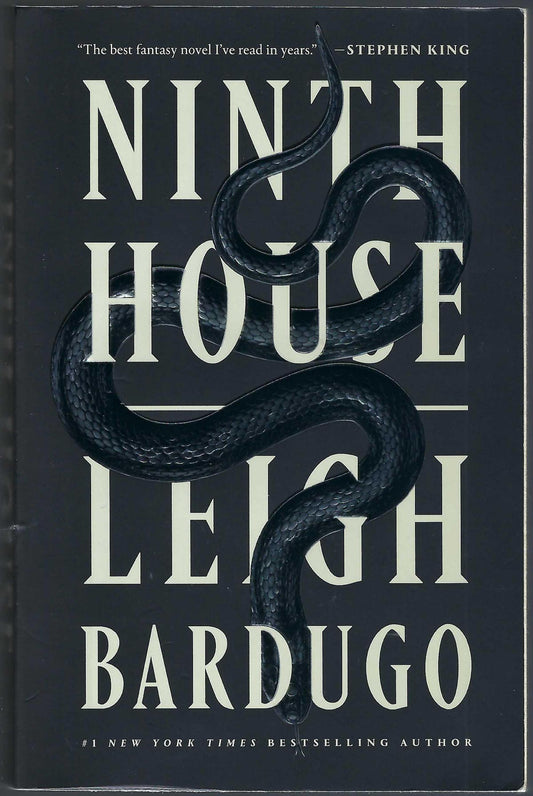 Front cover of Ninth House by Leigh Bardugo, featuring a dark black background with large cream-colored title and a coiled black snake running through the text.