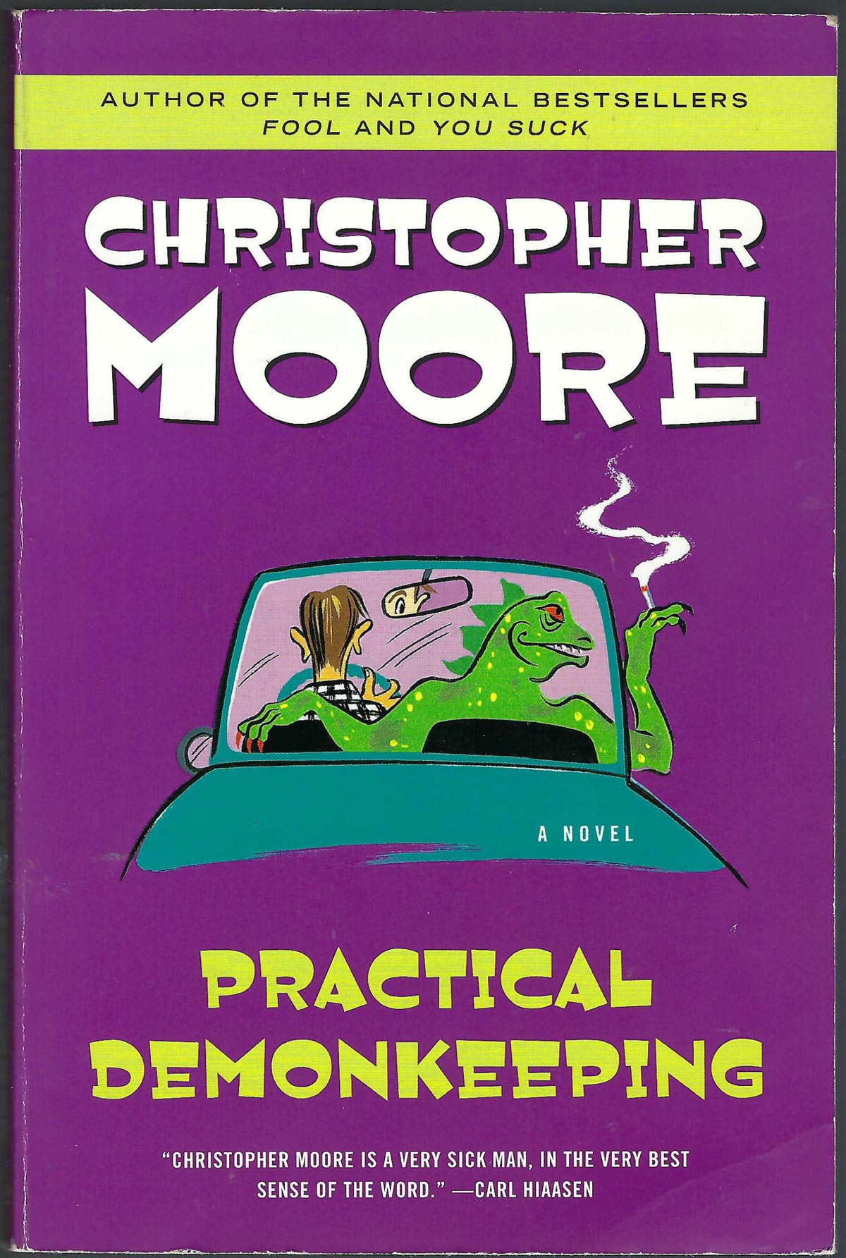 Front cover of Practical Demonkeeping by Christopher Moore, featuring a purple background with bold white author text, green title text, and an illustration of a green demon inside a teal car.