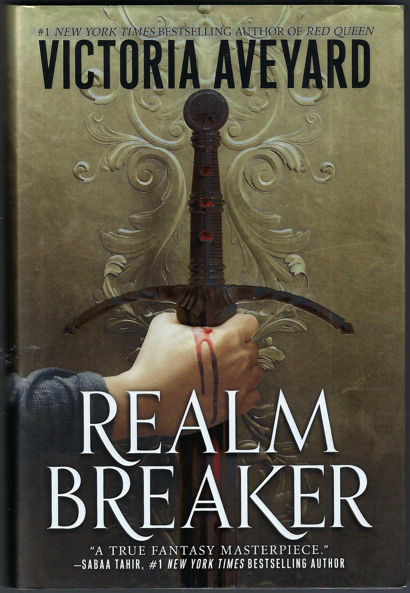 Front cover of Realm Breaker by Victoria Aveyard featuring a bloody hand holding a sword.